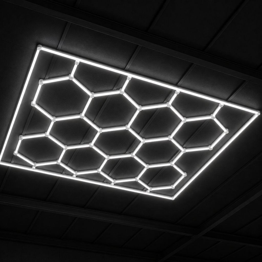 Panel LED hexagonal CorsaLux Hexa Pro encendido en blanco neutro sobre el techo de un taller