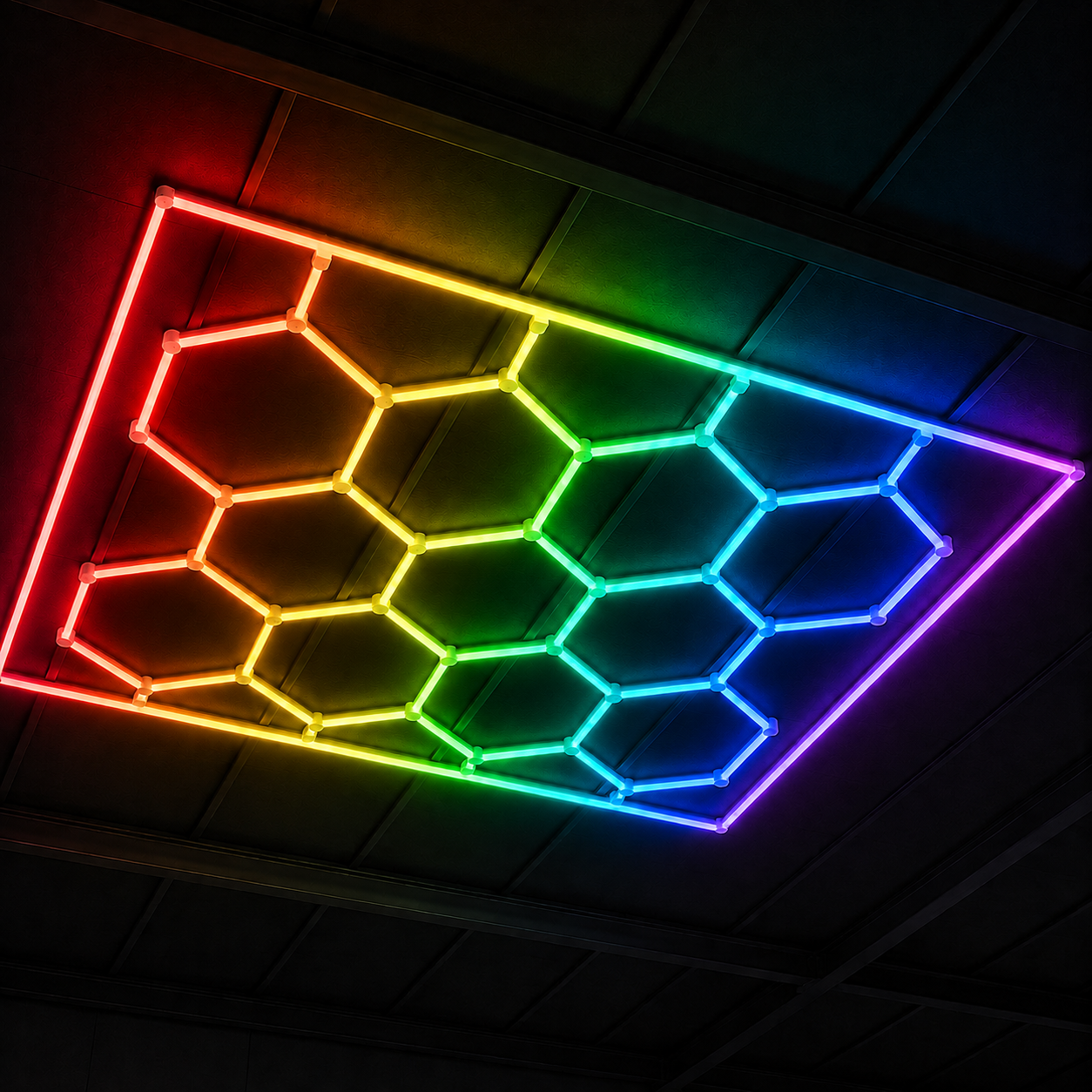 Panel LED hexagonal CorsaLux Hexa RGB encendido en colores sobre el techo de un garaje